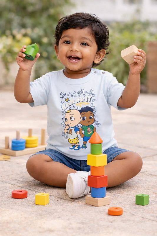 Playful Toddler Sitting Outdoors with Building Blocks in Cartoon T-Shirt